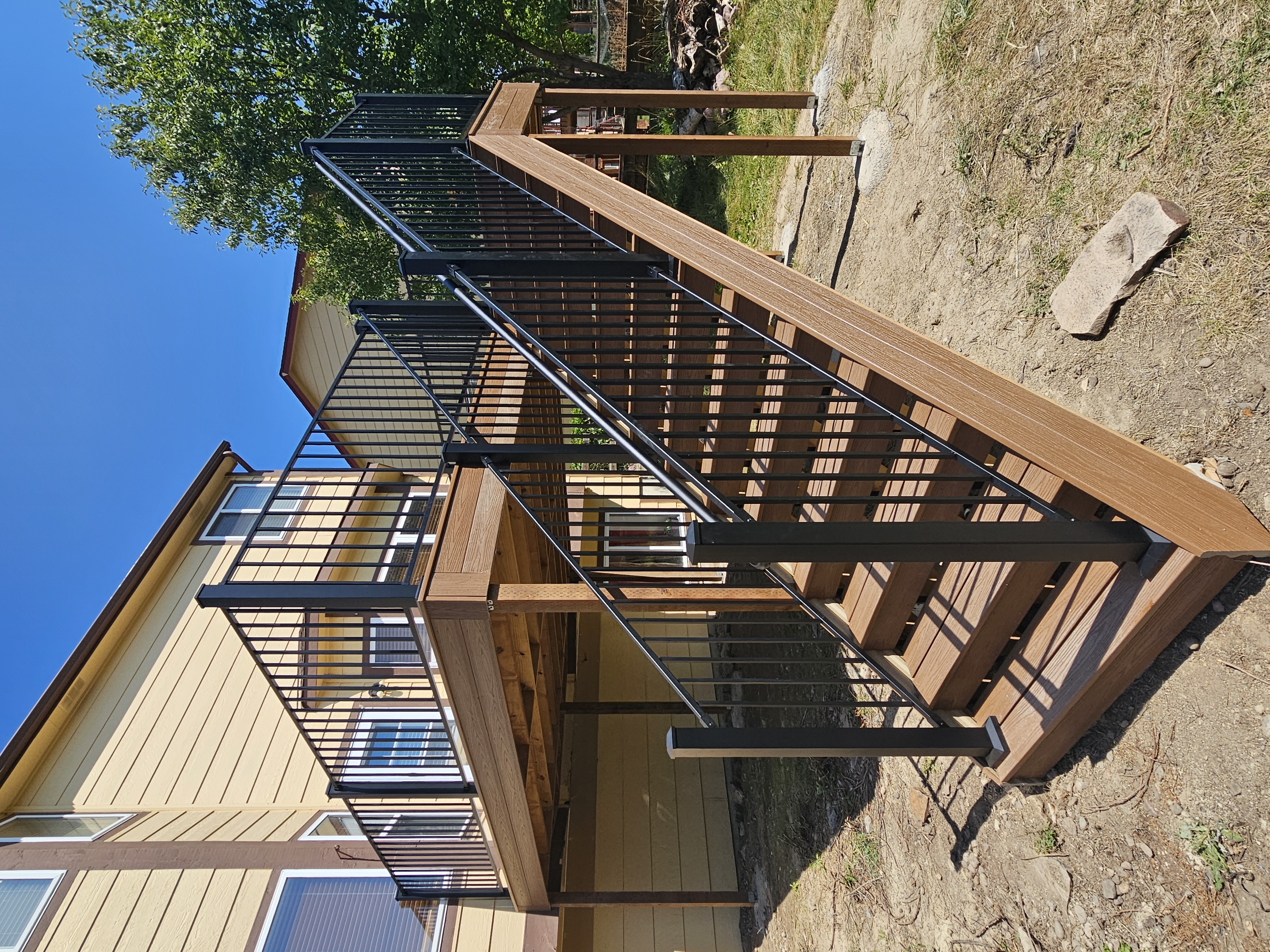 Walk-out deck with stairs to a landscaped yard