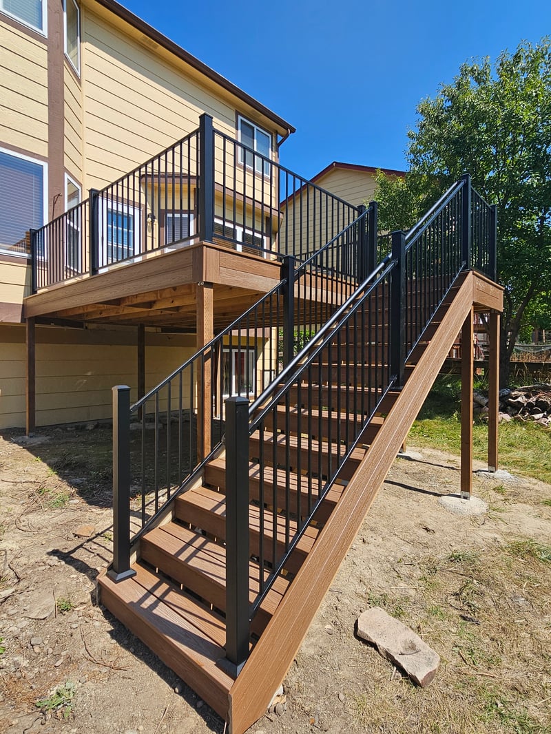 Walk-out deck with stairs to a landscaped yard