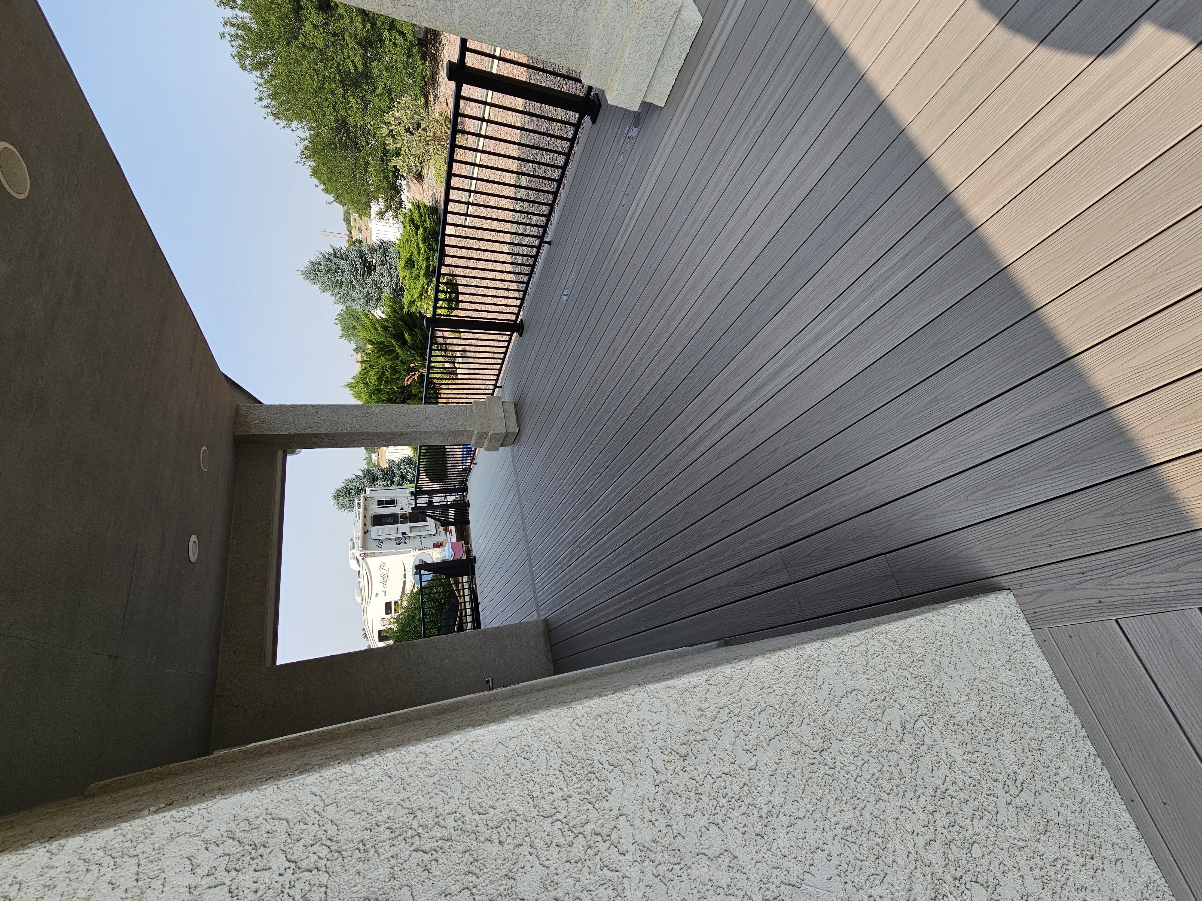 Walk-out deck with stairs to a landscaped yard