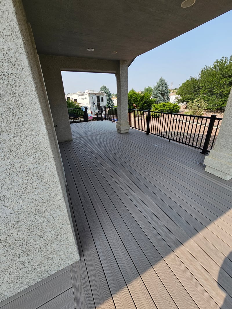 Walk-out deck with stairs to a landscaped yard