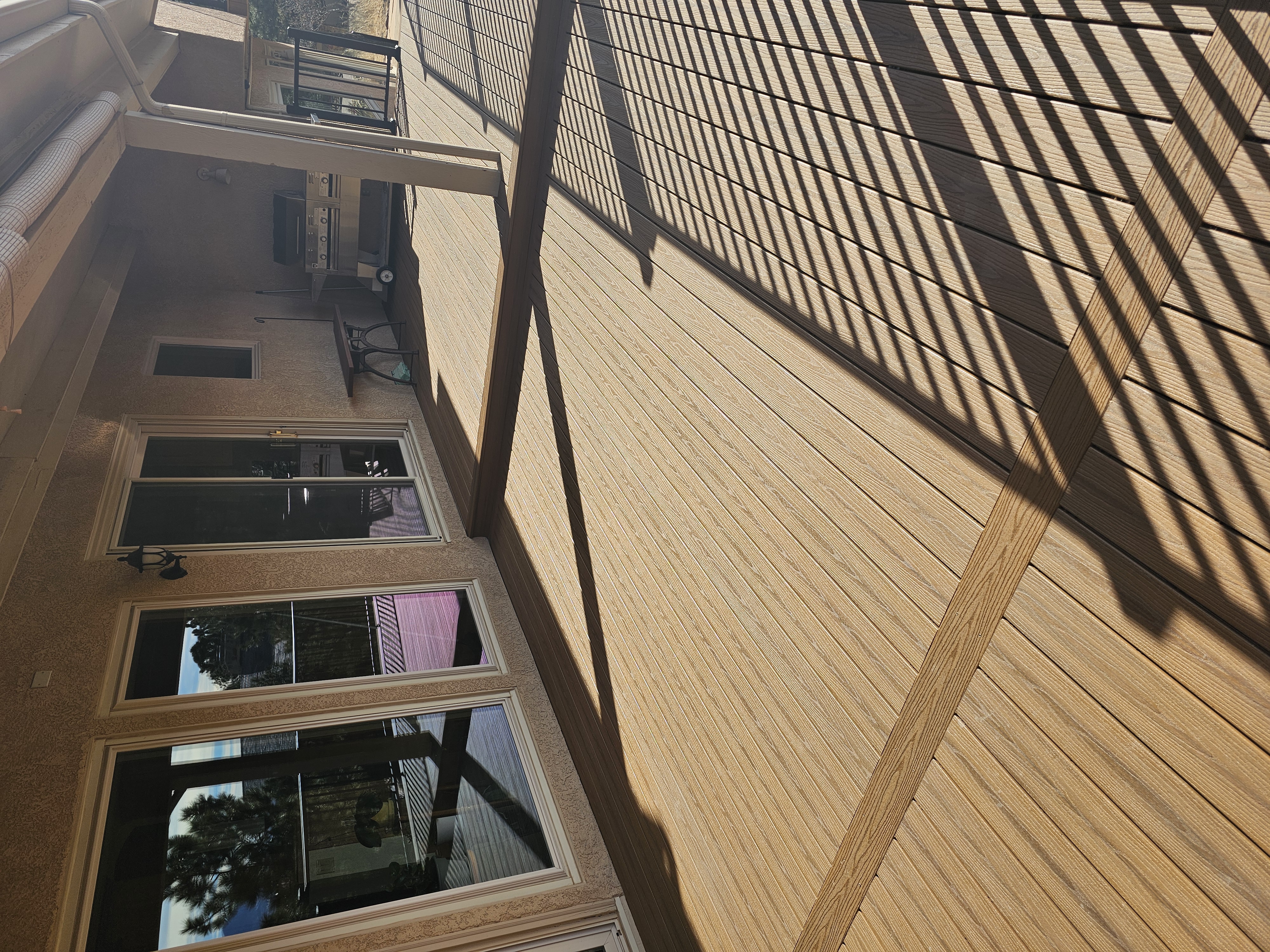Composite deck with black metal railings overlooking a mountain backyard