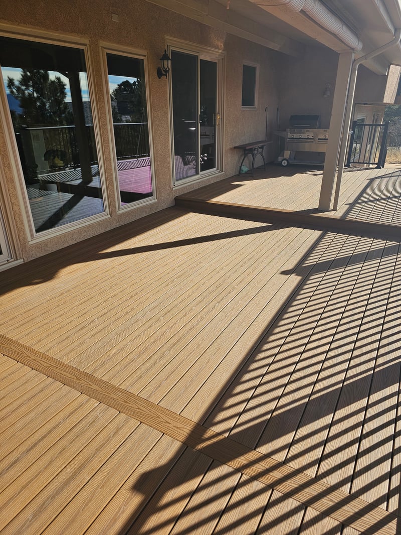 Composite deck with black metal railings overlooking a mountain backyard