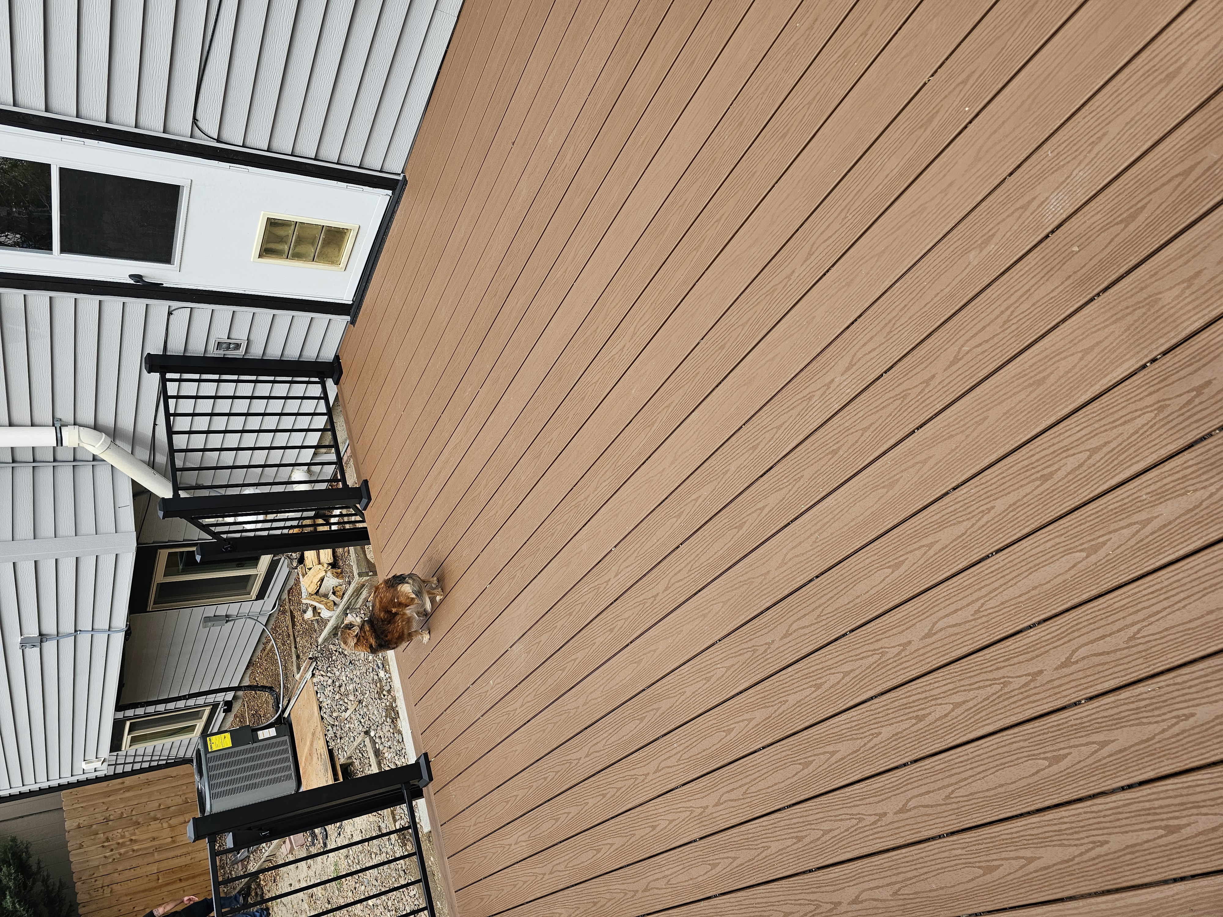 Walk-out deck with stairs to a landscaped yard