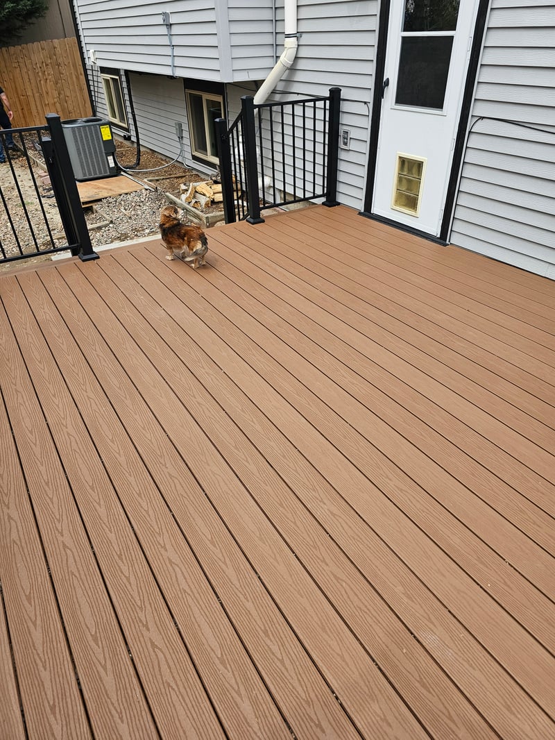 Walk-out deck with stairs to a landscaped yard