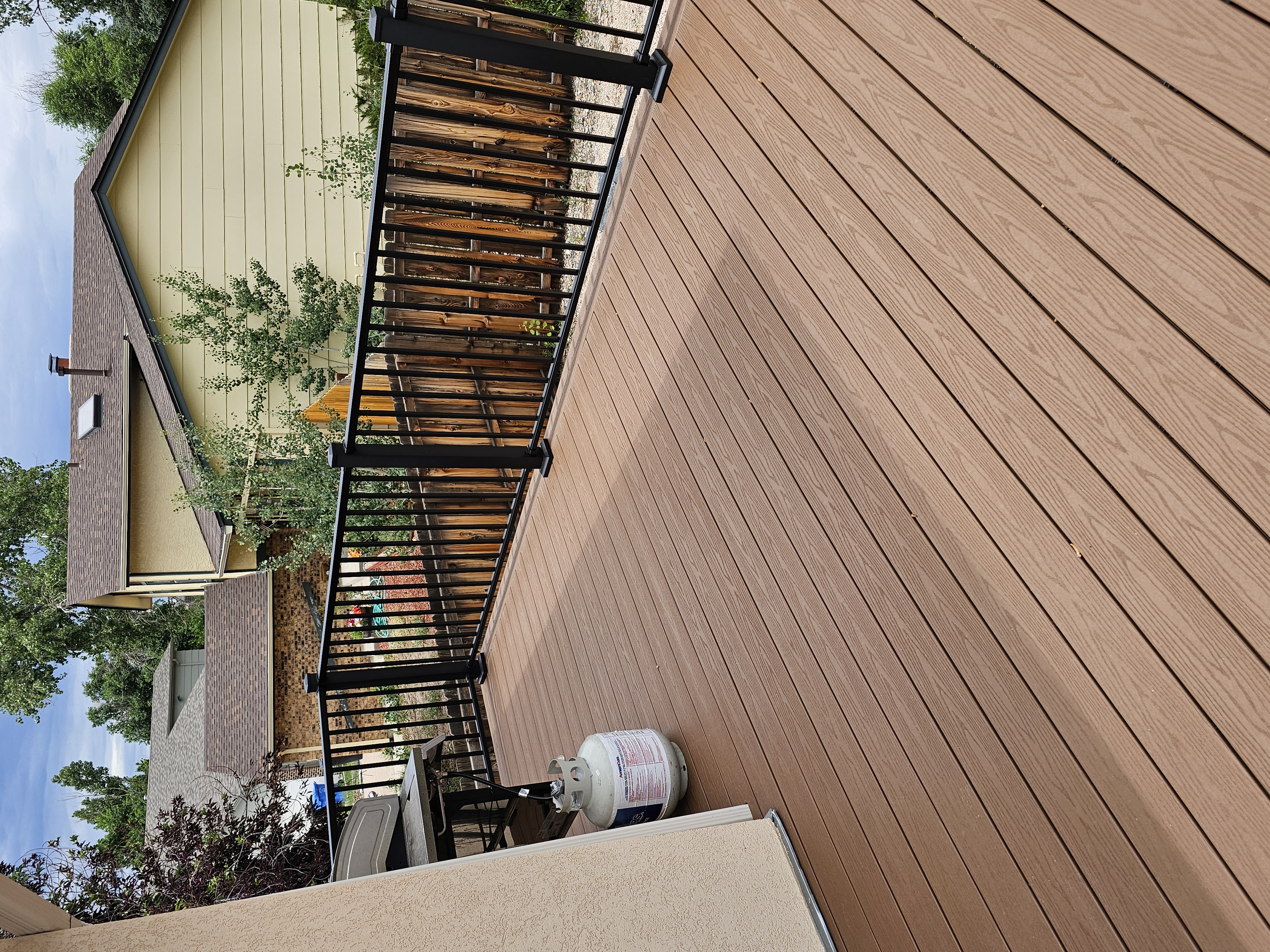 Walk-out deck with stairs to a landscaped yard