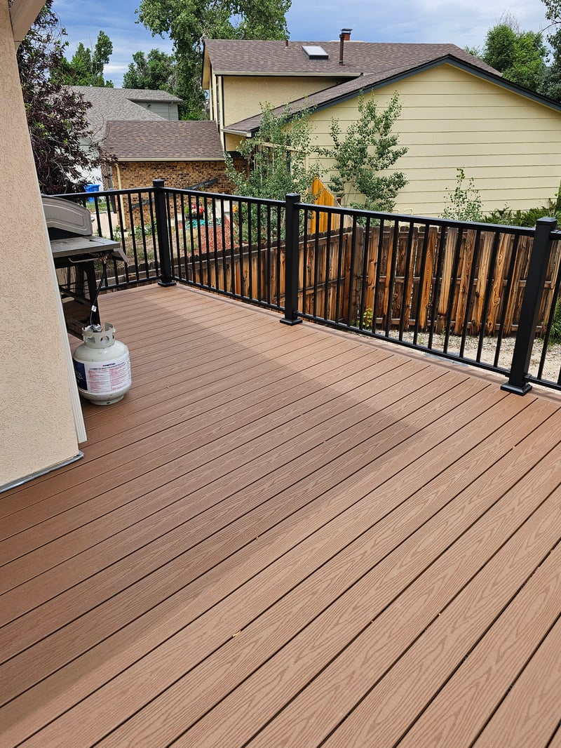 Walk-out deck with stairs to a landscaped yard