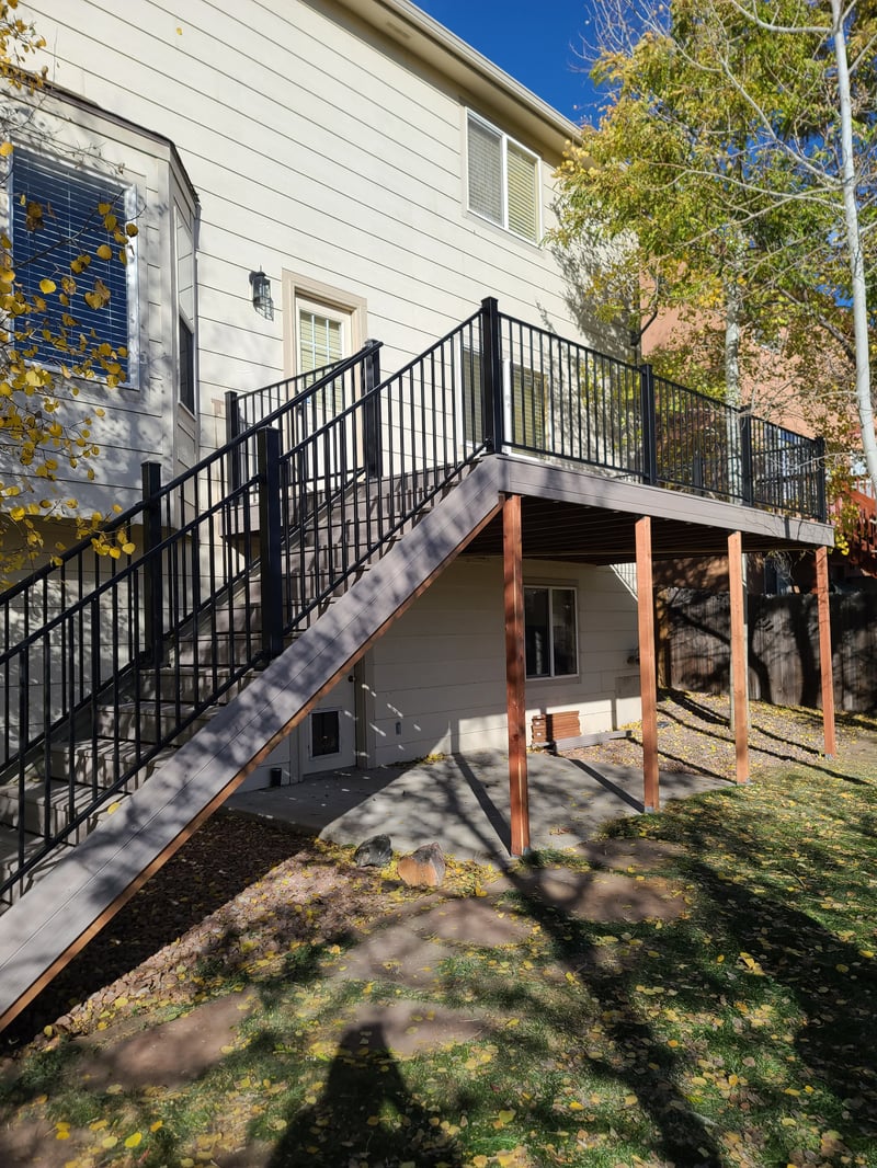 Walk-out deck with stairs to a landscaped yard