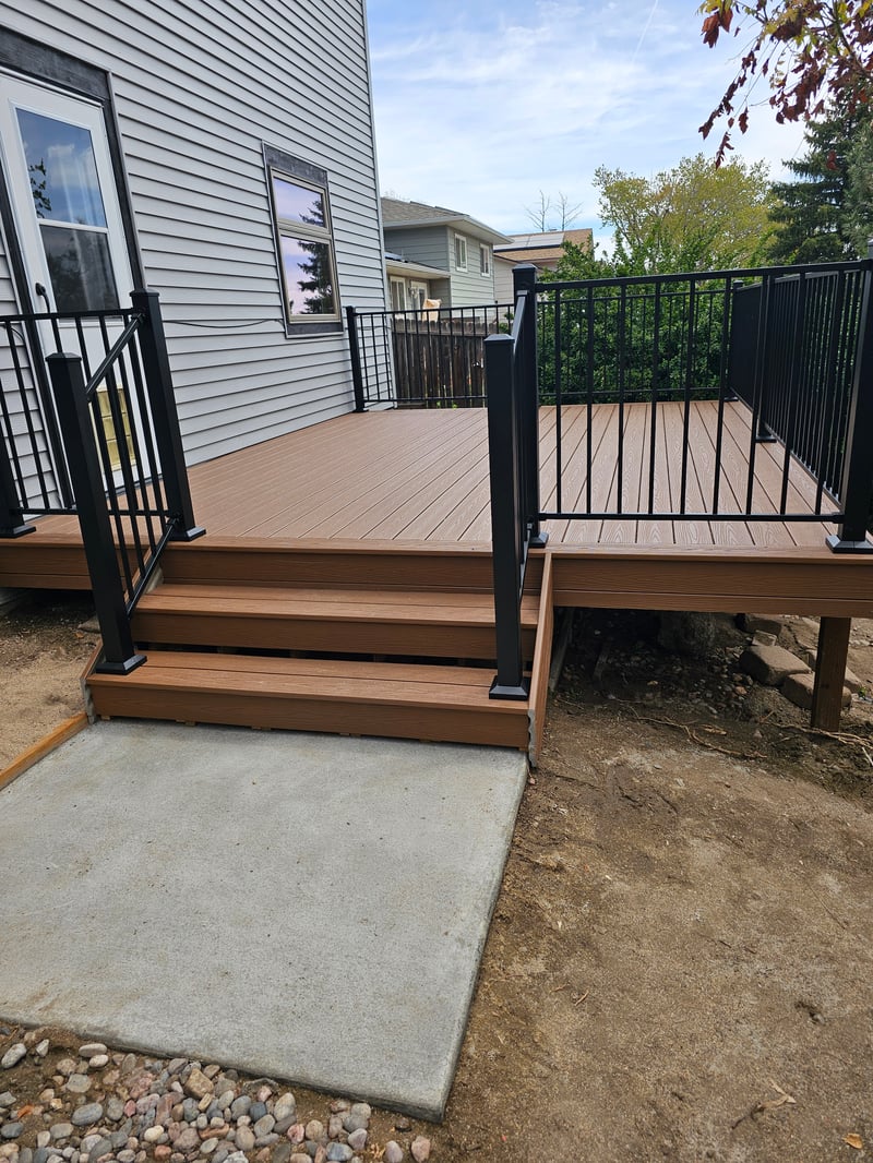 Stained wood deck with post-cap lighting at dusk
