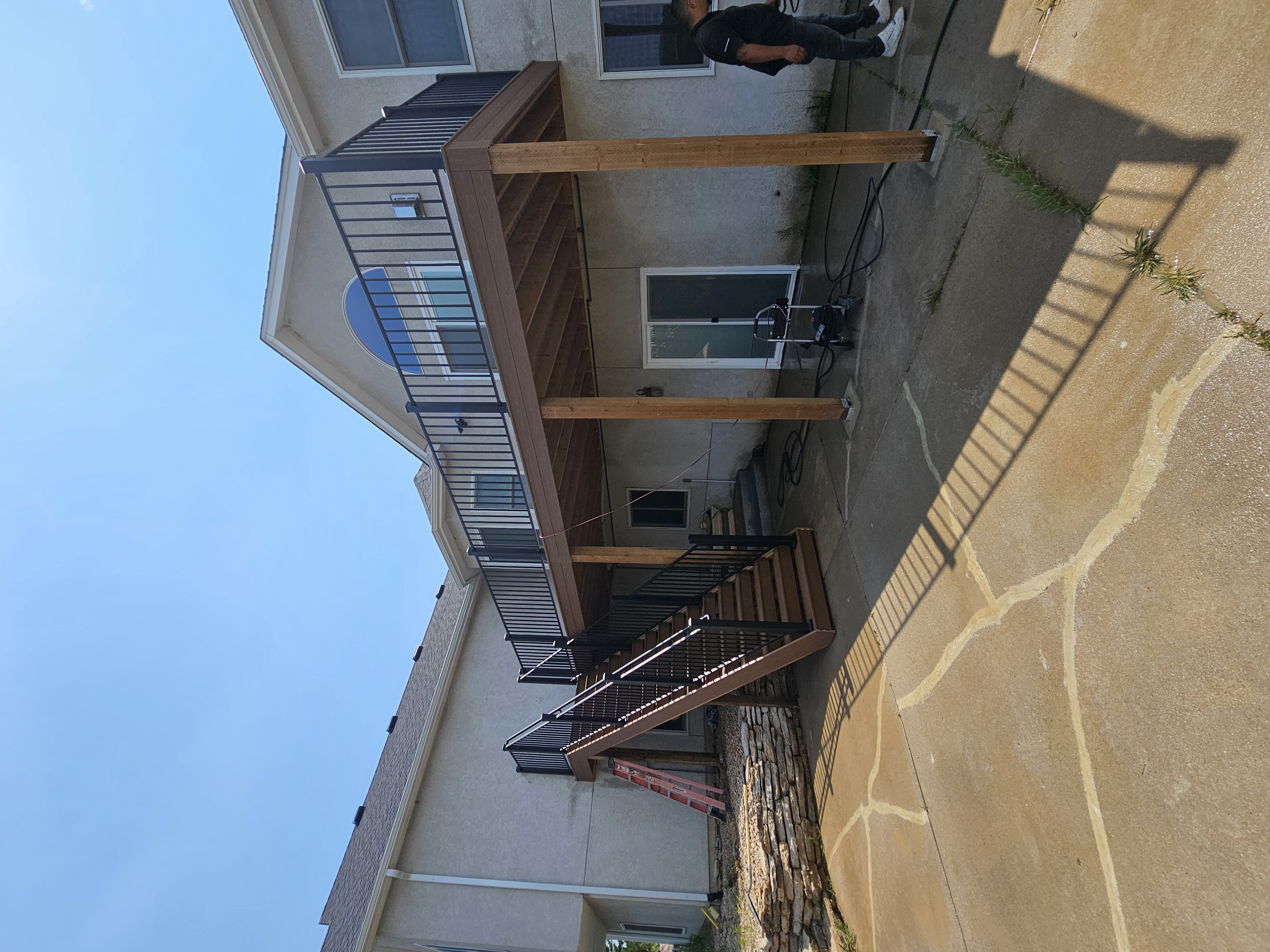 Composite deck with black metal railings overlooking a mountain backyard