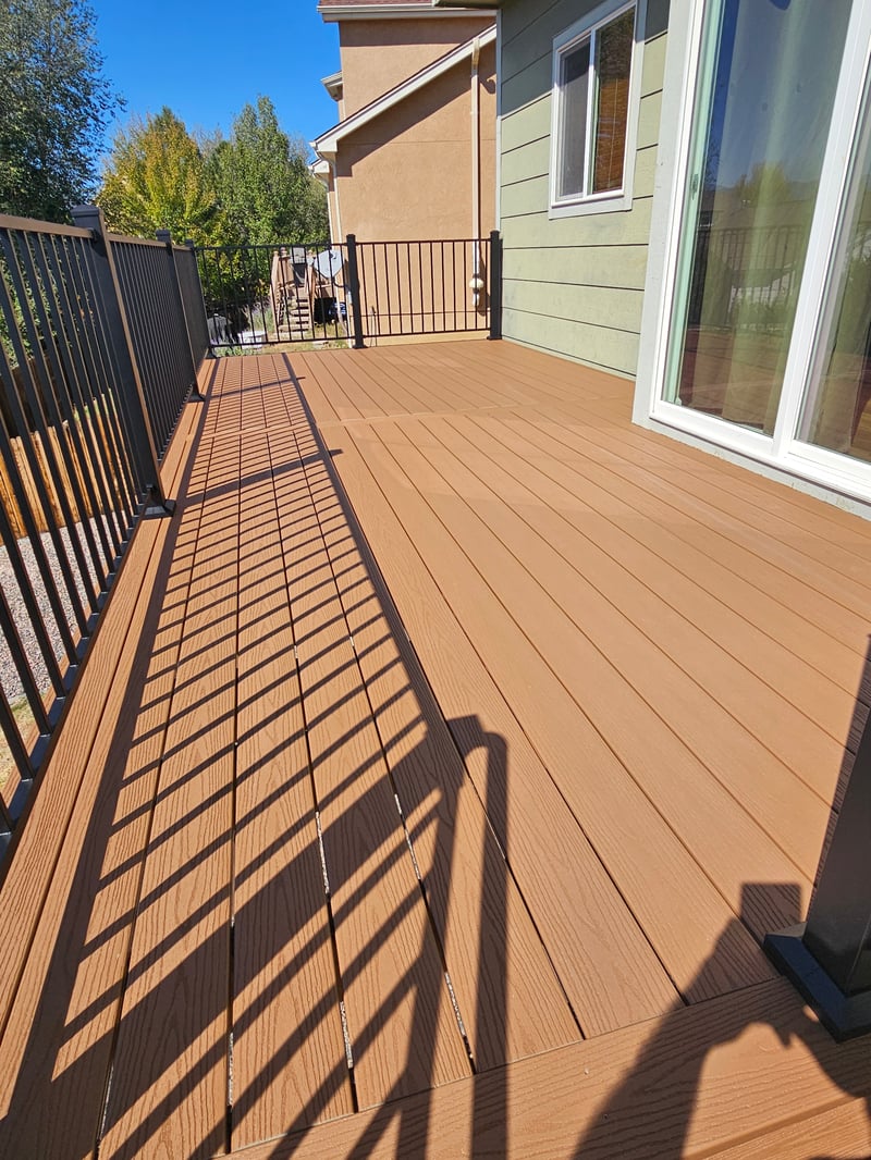 Stained wood deck with post-cap lighting at dusk