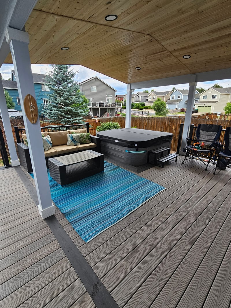 Composite deck with black metal railings overlooking a mountain backyard