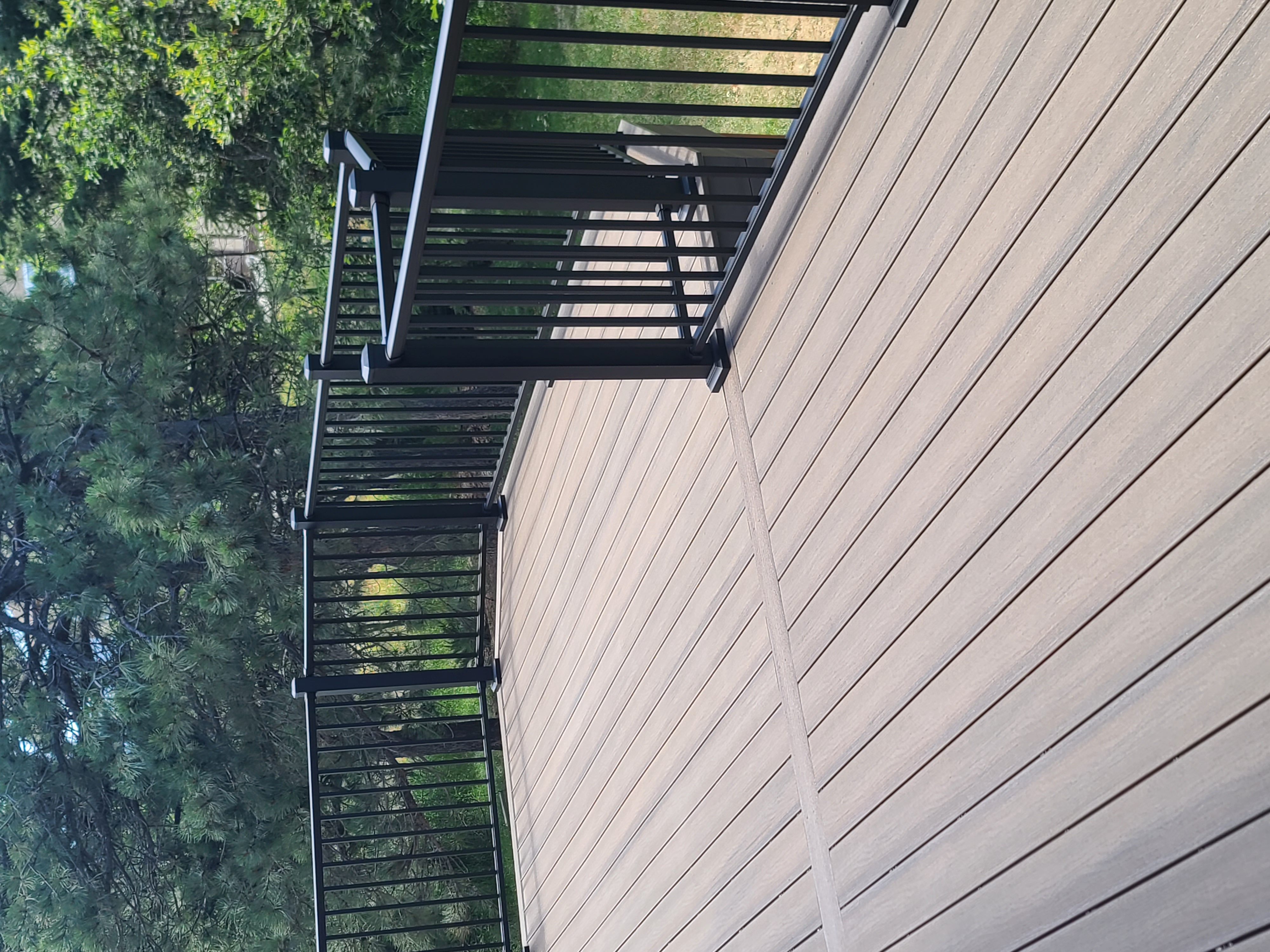 Walk-out deck with stairs to a landscaped yard
