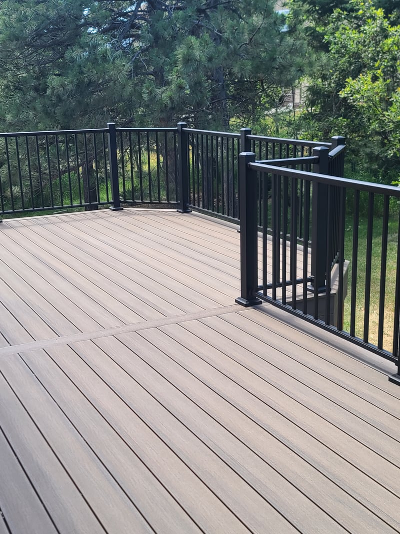 Walk-out deck with stairs to a landscaped yard