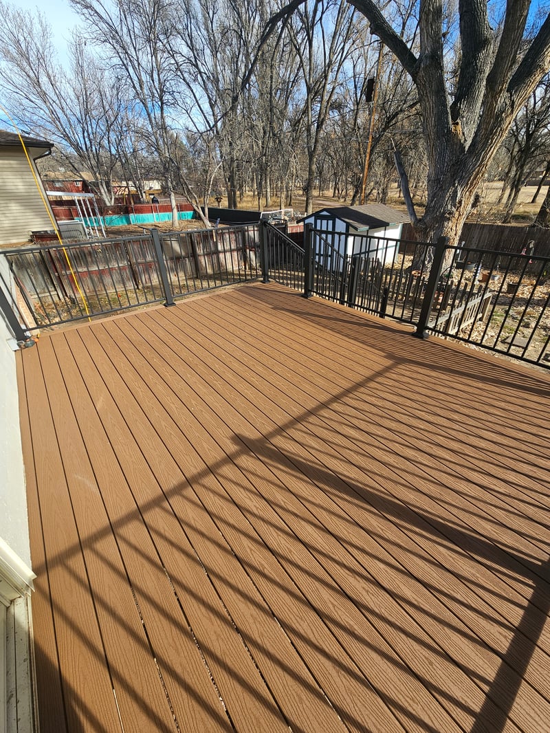 Walk-out deck with stairs to a landscaped yard