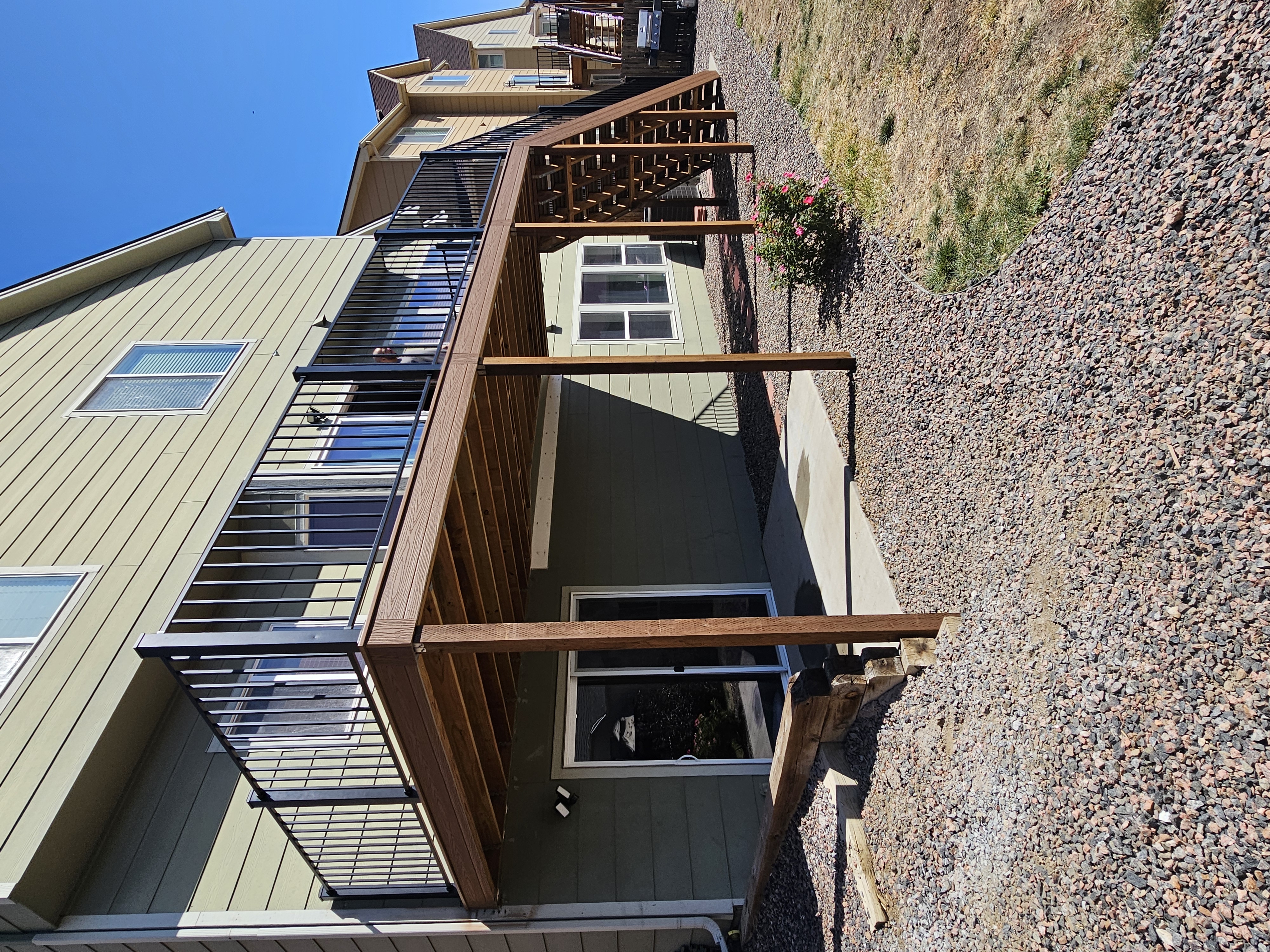 Walk-out deck with stairs to a landscaped yard