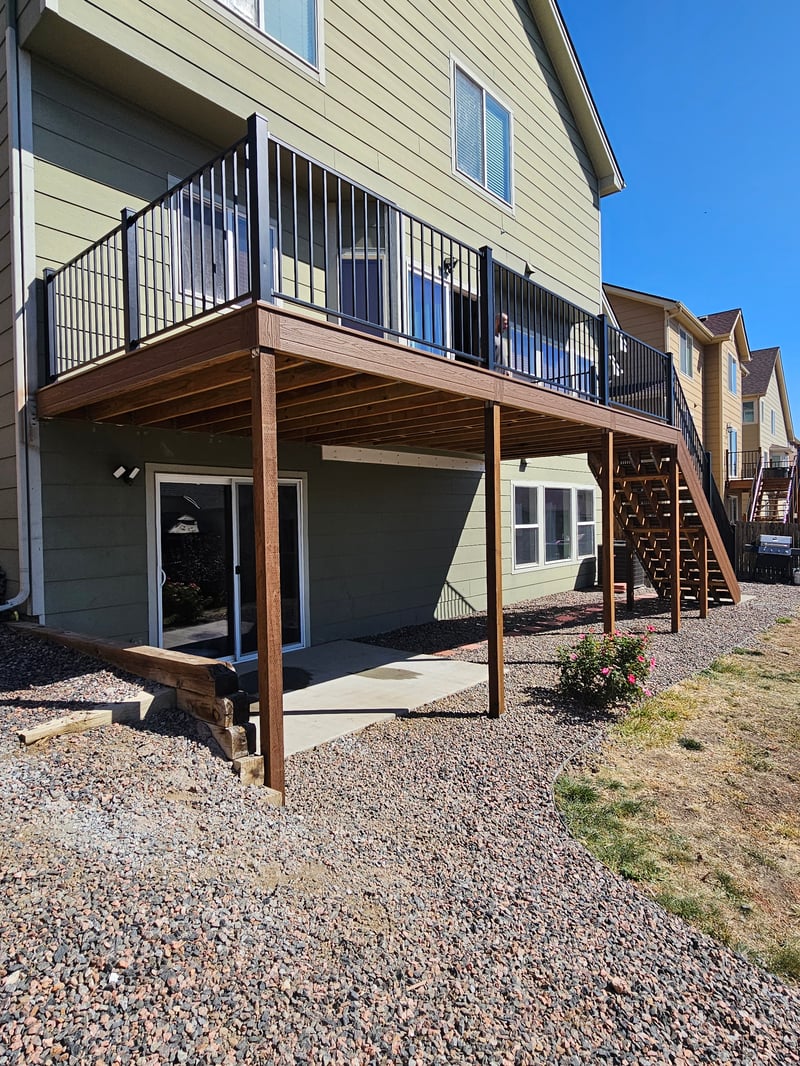 Walk-out deck with stairs to a landscaped yard