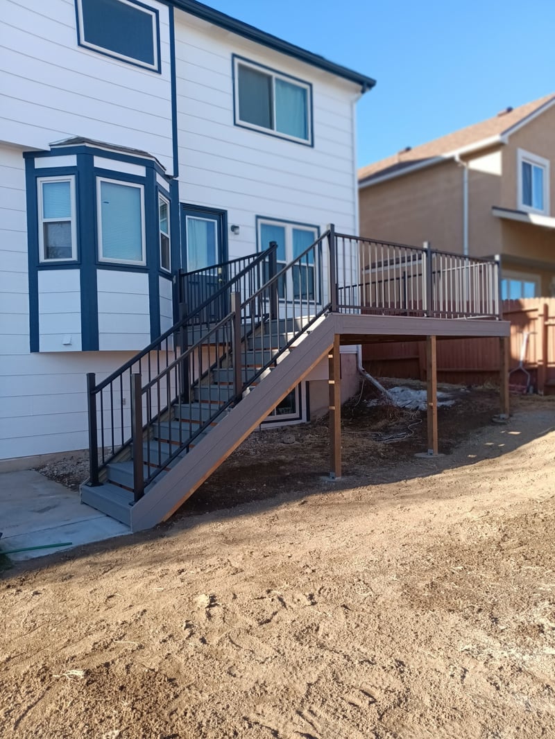 Walk-out deck with stairs to a landscaped yard