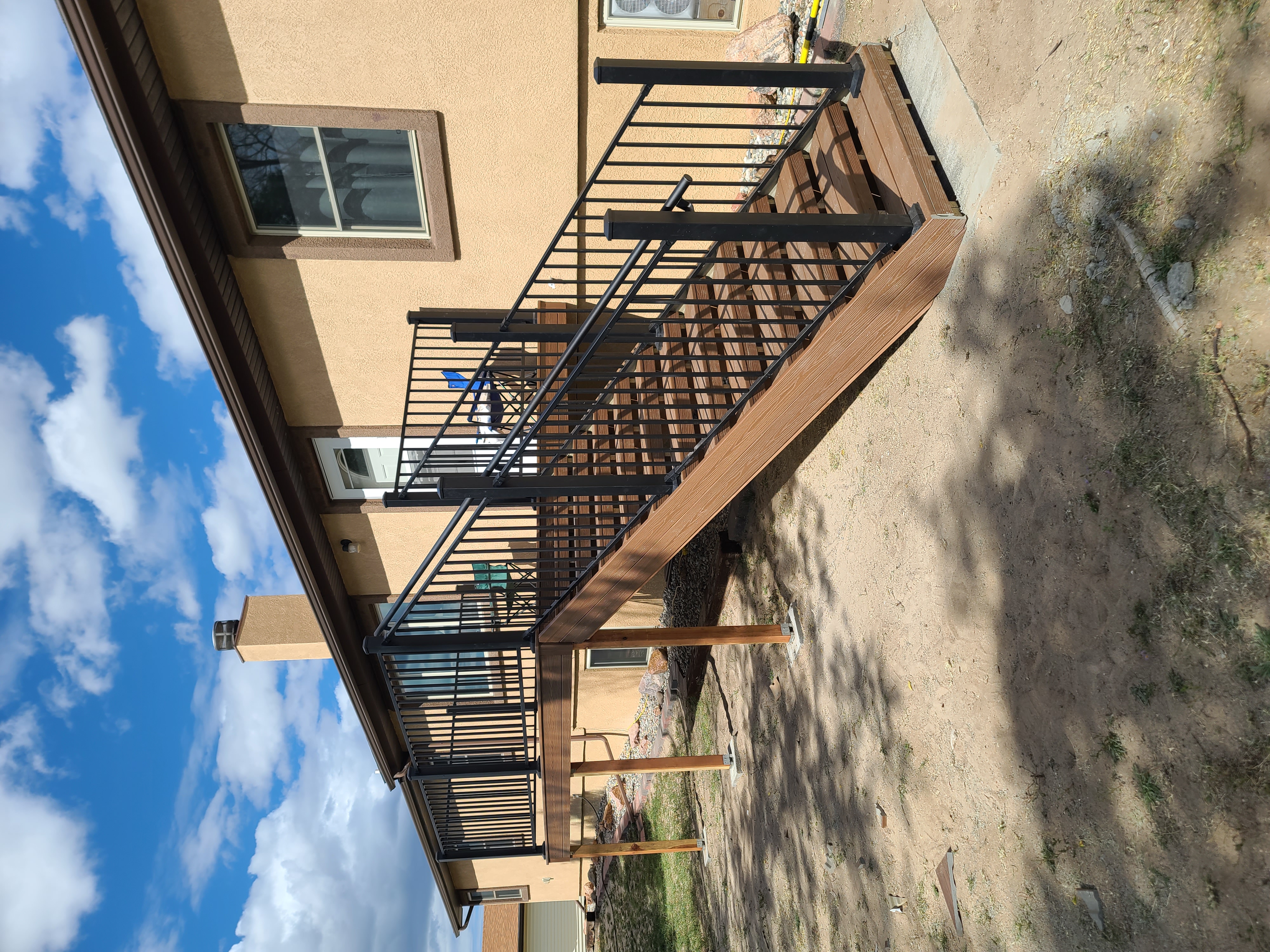 Composite deck with black metal railings overlooking a mountain backyard
