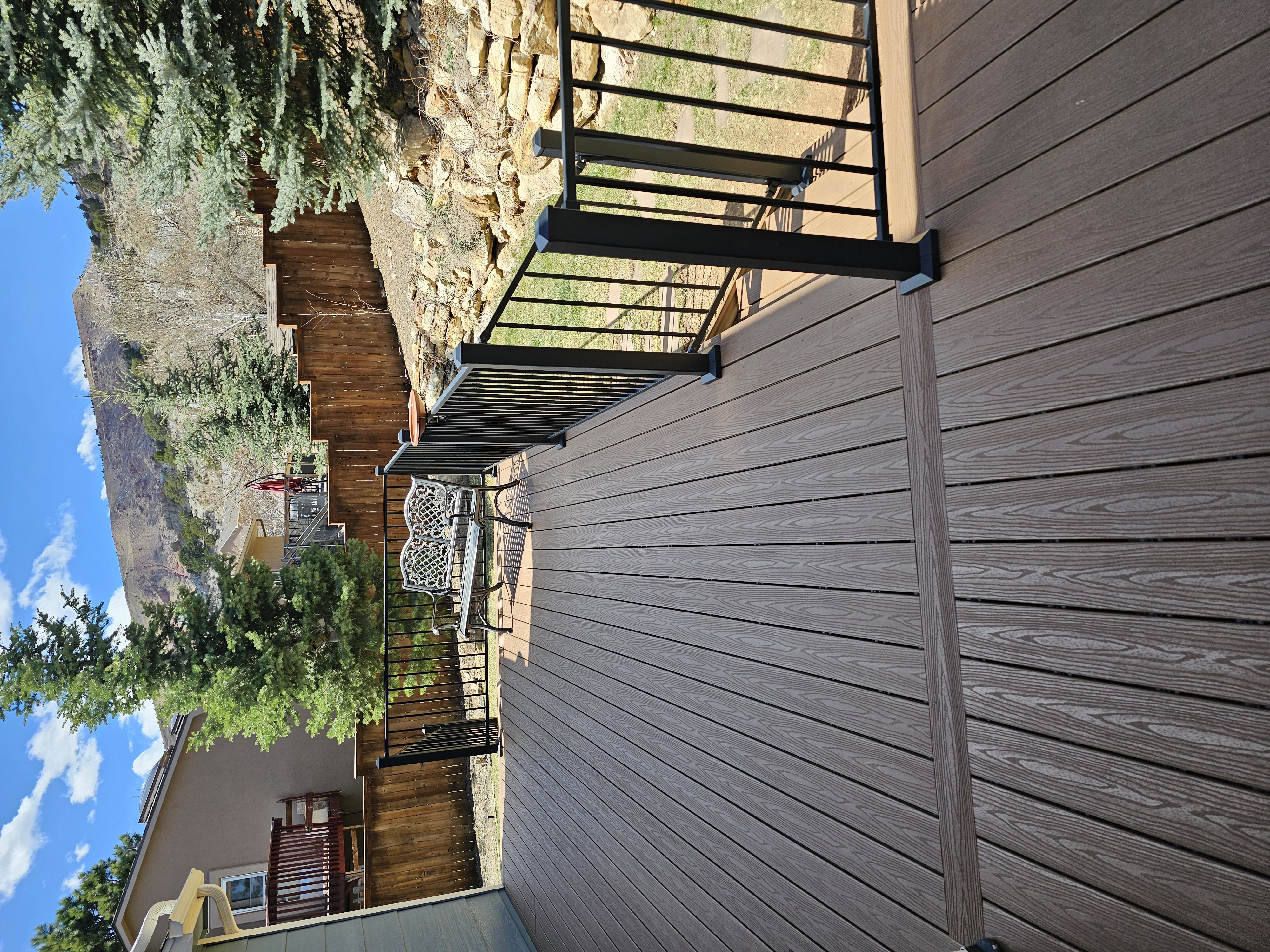 Walk-out deck with stairs to a landscaped yard