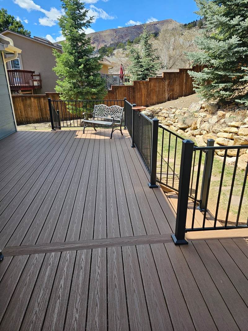 Walk-out deck with stairs to a landscaped yard