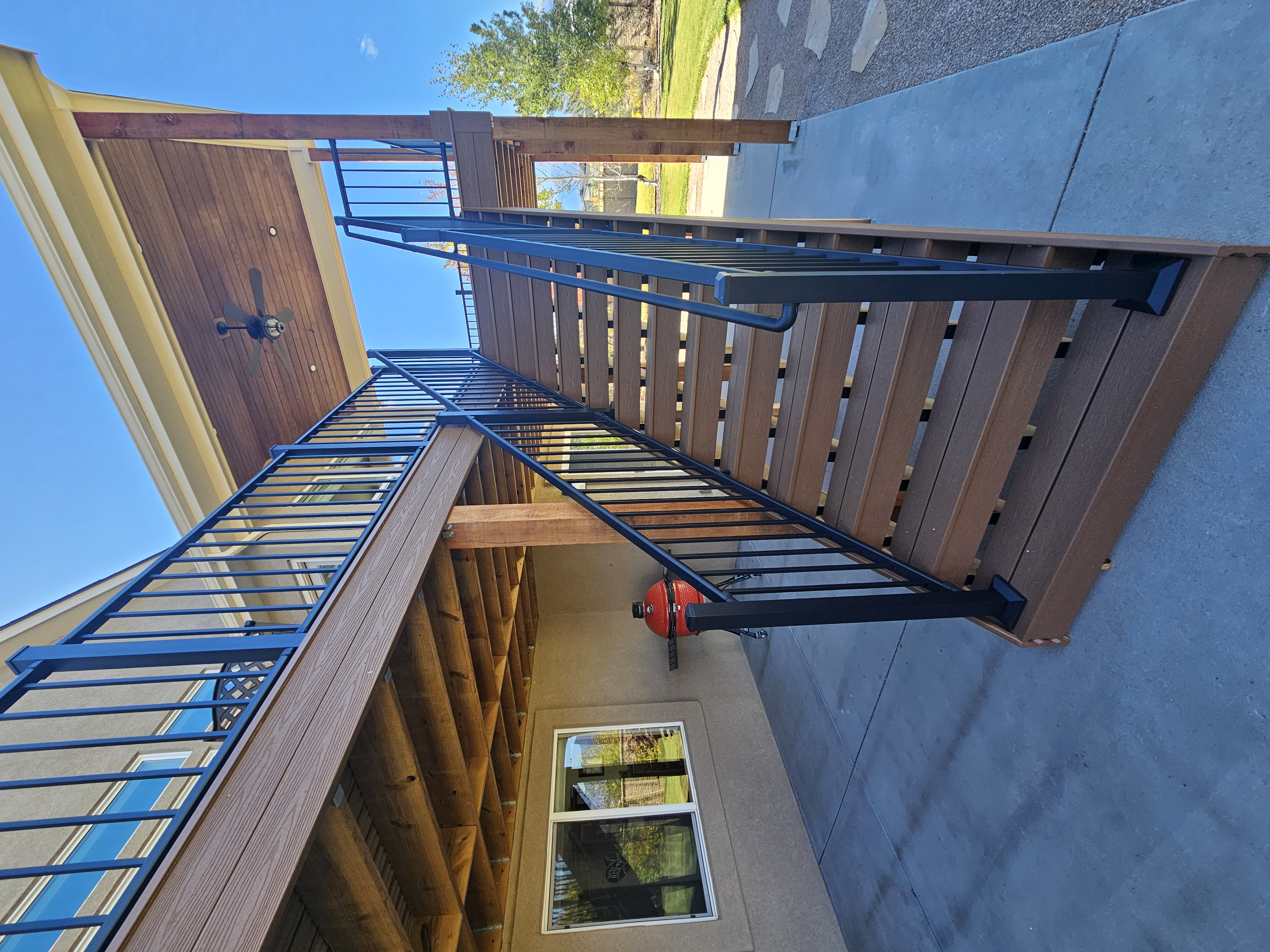 Composite deck with black metal railings overlooking a mountain backyard
