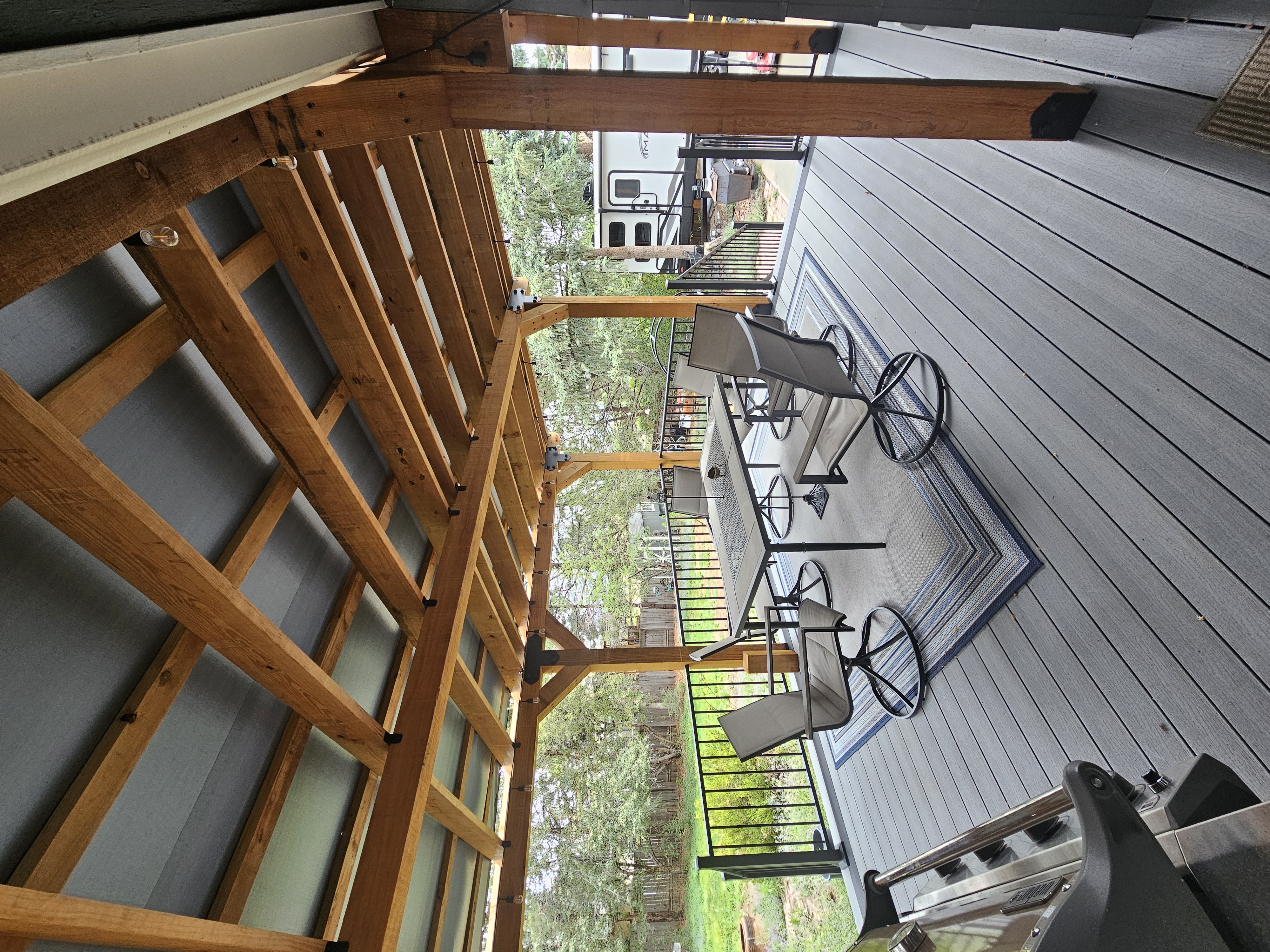 Composite deck with black metal railings overlooking a mountain backyard