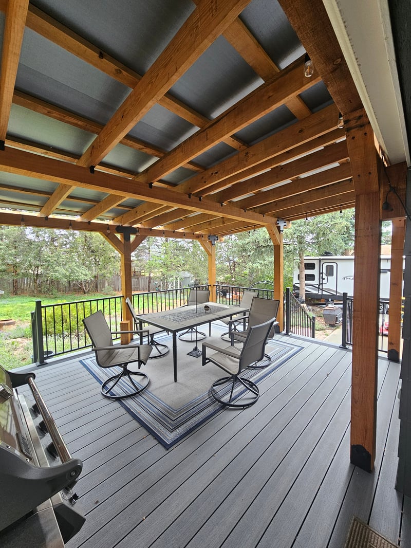 Composite deck with black metal railings overlooking a mountain backyard